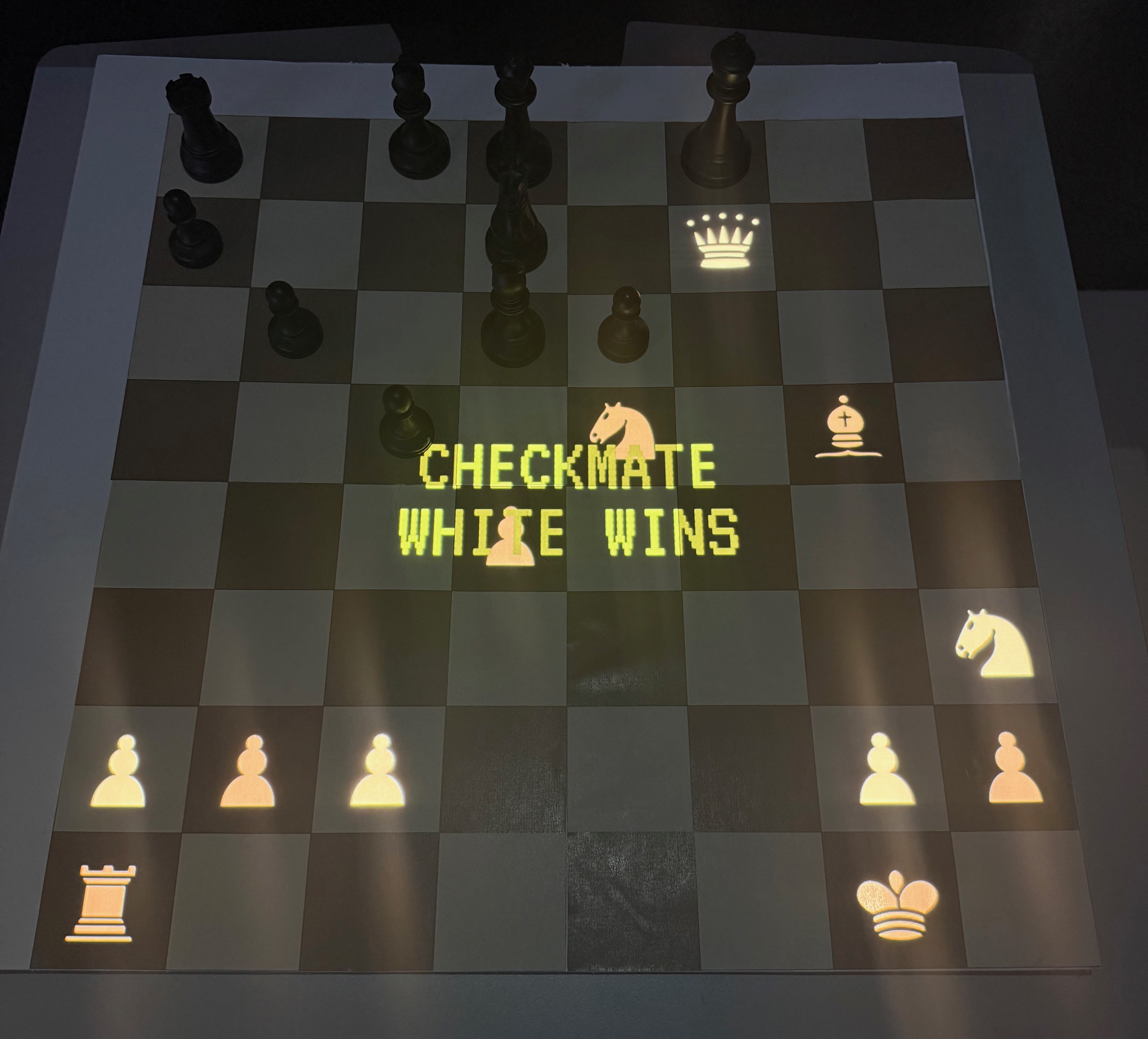The board in the dark with projected pieces glowing